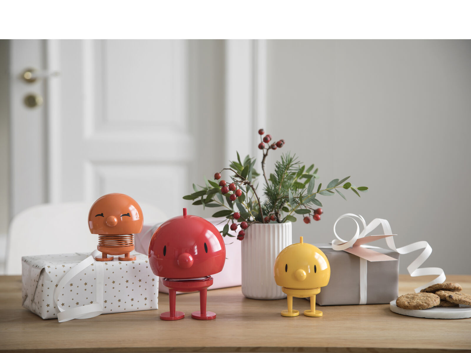 桌上的禮物包裝旁，站著橘色 Bimble、紅色與黃色 Bumble