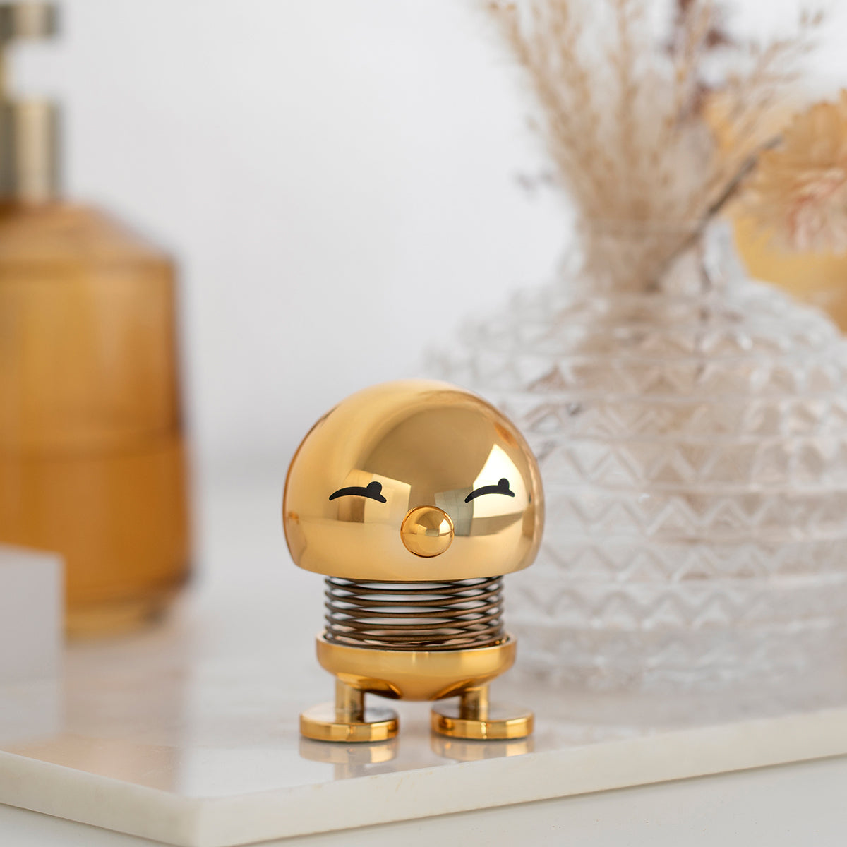 金色 Bumble 擺在白色大理石托盤上